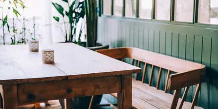 Green panelled dining room with a timber table
